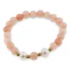 Bratara pe elastic Perle de cultura, bumbi aurii si Cuart piersica sfere 8mm