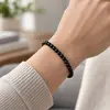 Bratara din obsidian natural, sfere de 4 mm, pe elastic, lungime 19 cm – imagine de prezentare în context
